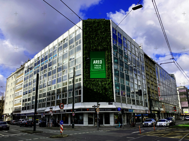 Standort Düsseldorf. Mehrstöckiges Büro-Glasgebäude, an einer großen Straßenkreuzung mit mehreren Autos.