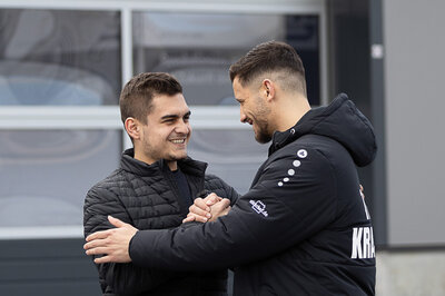 Kevin Arnold klatscht gerade einen weiteren Mann namens Ardian Krasniqi ab und umarmen sich fast dabei. Beide strahlen mit einem lächeln.
