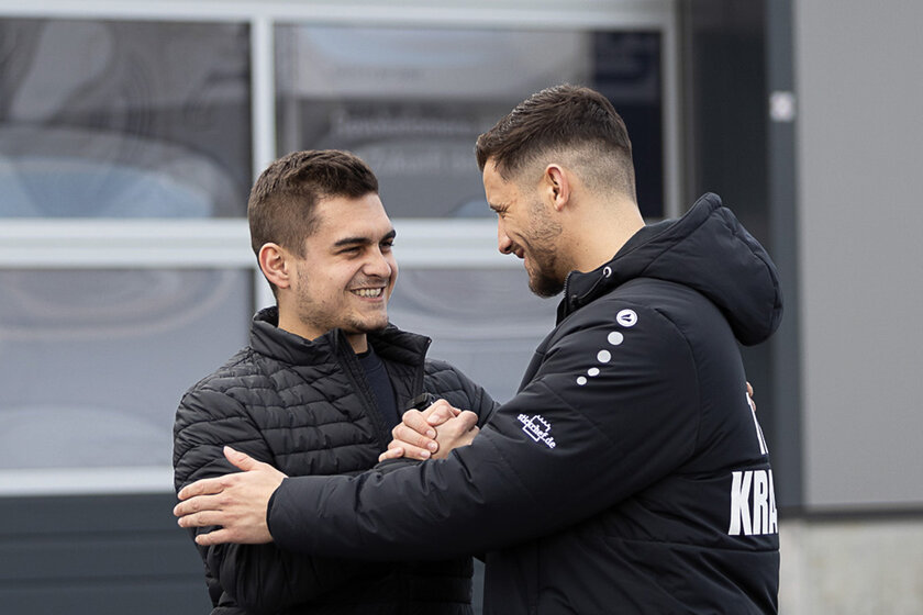 Kevin Arnold klatscht gerade einen weiteren Mann namens Ardian Krasniqi ab und umarmen sich fast dabei. Beide strahlen mit einem lächeln.