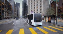 Ein autonomer Mover hält an einer Bushaltestelle in einer mehrspurigen Großstadtstraße.