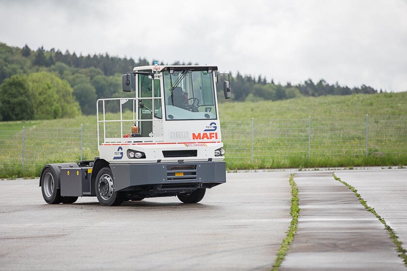 Ein autonom fahrender Terminal-Traktor der Firma MAFI, umgebaut mit NX NextMotion, bewegt sich fahrerlos über einen Übungsplatz.