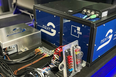 Mehrere technische Elemente und Kabel mit Arnold NextG und b-plus aufklebern sind in einem Auto angeschlossen.