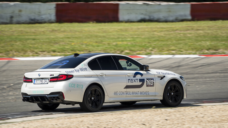Ein BMW M5 von Arnold NextG fährt auf einer Rennstrecke.