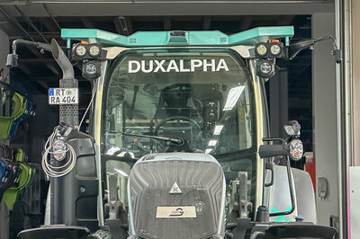Eine Front eines Traktors welcher Cyan Silber ist und mit Logos von Arnold NextG und DuxAlpha.
