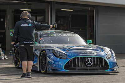Ein Mercedes GT3 Rennauto von Arnold NextG fährt aus der Box an einer Rennstrecke. Ein Mitarbeiter streckt den rechten Arm aus und zeigt dem Fahrer einen Daumen hoch.