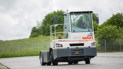 Ein autonom fahrender Terminal-Traktor der Firma MAFI, umgebaut mit NX NextMotion, bewegt sich fahrerlos über einen Übungsplatz.