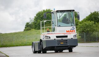 Ein autonom fahrender Terminal-Traktor der Firma MAFI, umgebaut mit NX NextMotion, bewegt sich fahrerlos über einen Übungsplatz.