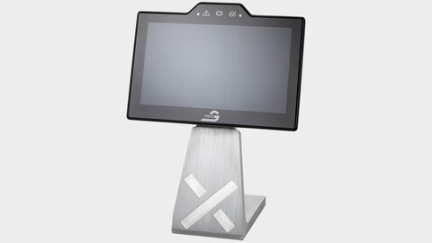 Das Arnold NextG Touch Display auf einer Metallkonstruktion mit Ständer welches auf einer weißen Fläche steht. Auf dem Ständer ist ein X reingefrät und der Bildschirm ist schwarz.