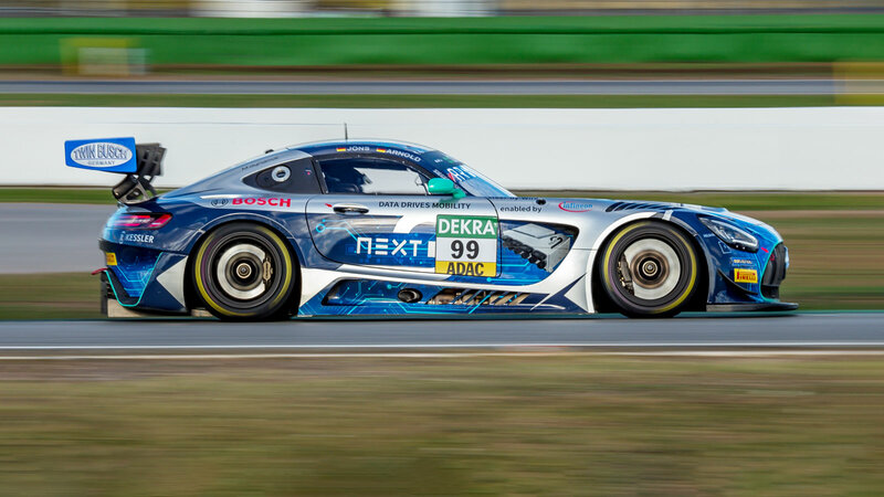 Ein Mercedes GT3 von Arnold NextG fährt schnell auf einer Rennstrecke von links nach rechts. Alles drum herum ist unscharf.