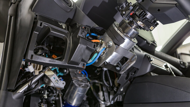 Ein aufgeschraubtes Lenkradgehäuse, welches komplett umgebaut worden ist. Lenksäule weg, Force Feedback Motor, am Lenkrad, von NX NextMotion rein. Mehrere bunte Kabel wurden neu Verlegt.