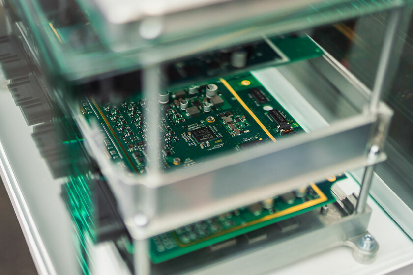 Eine grüne Platine die hinter einer Glasscheibe ausgestellt wird und zum NX NextMotion gehört.
