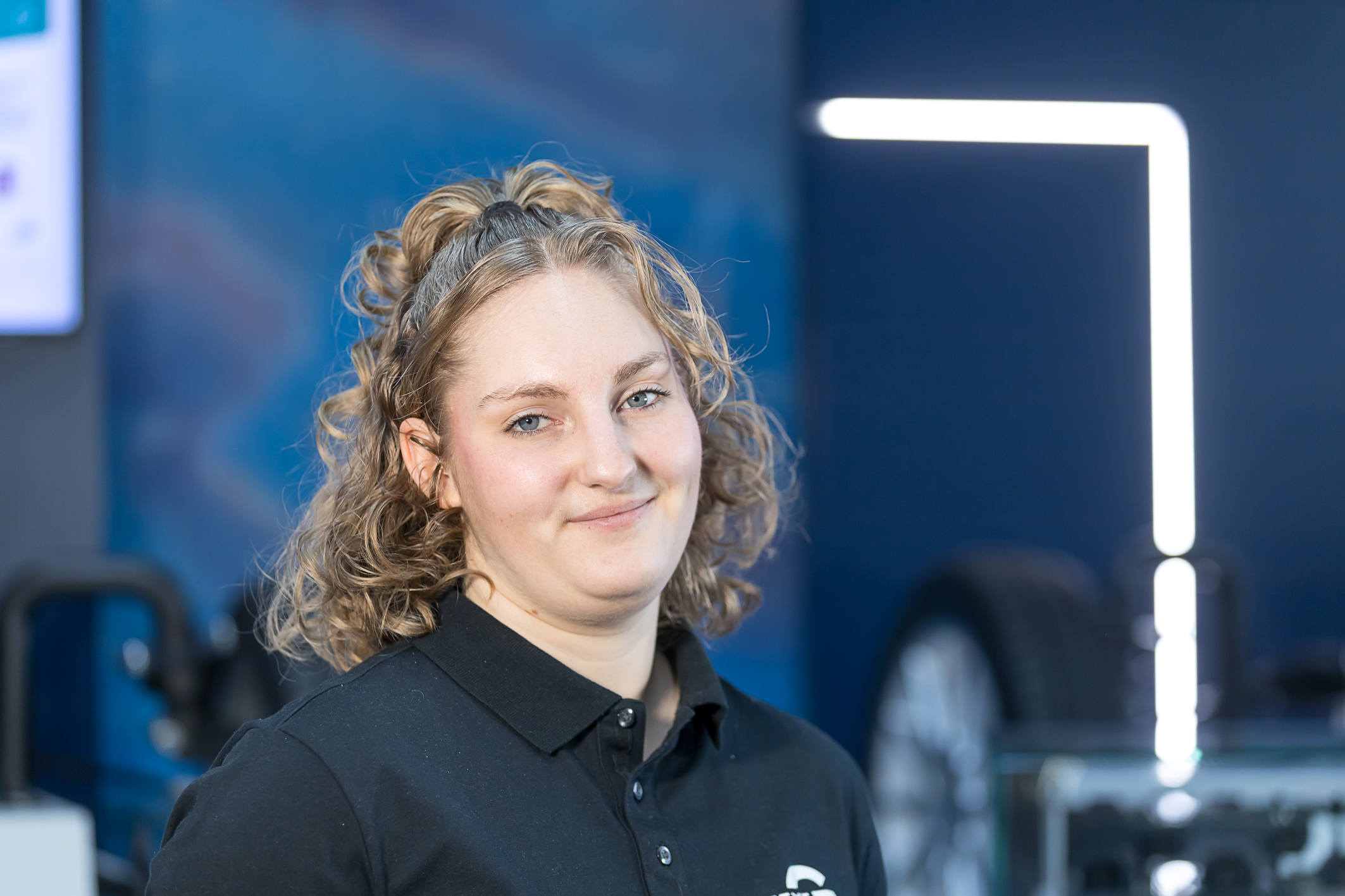 Eine Dame mit blonden Haaren lächelt einen an.